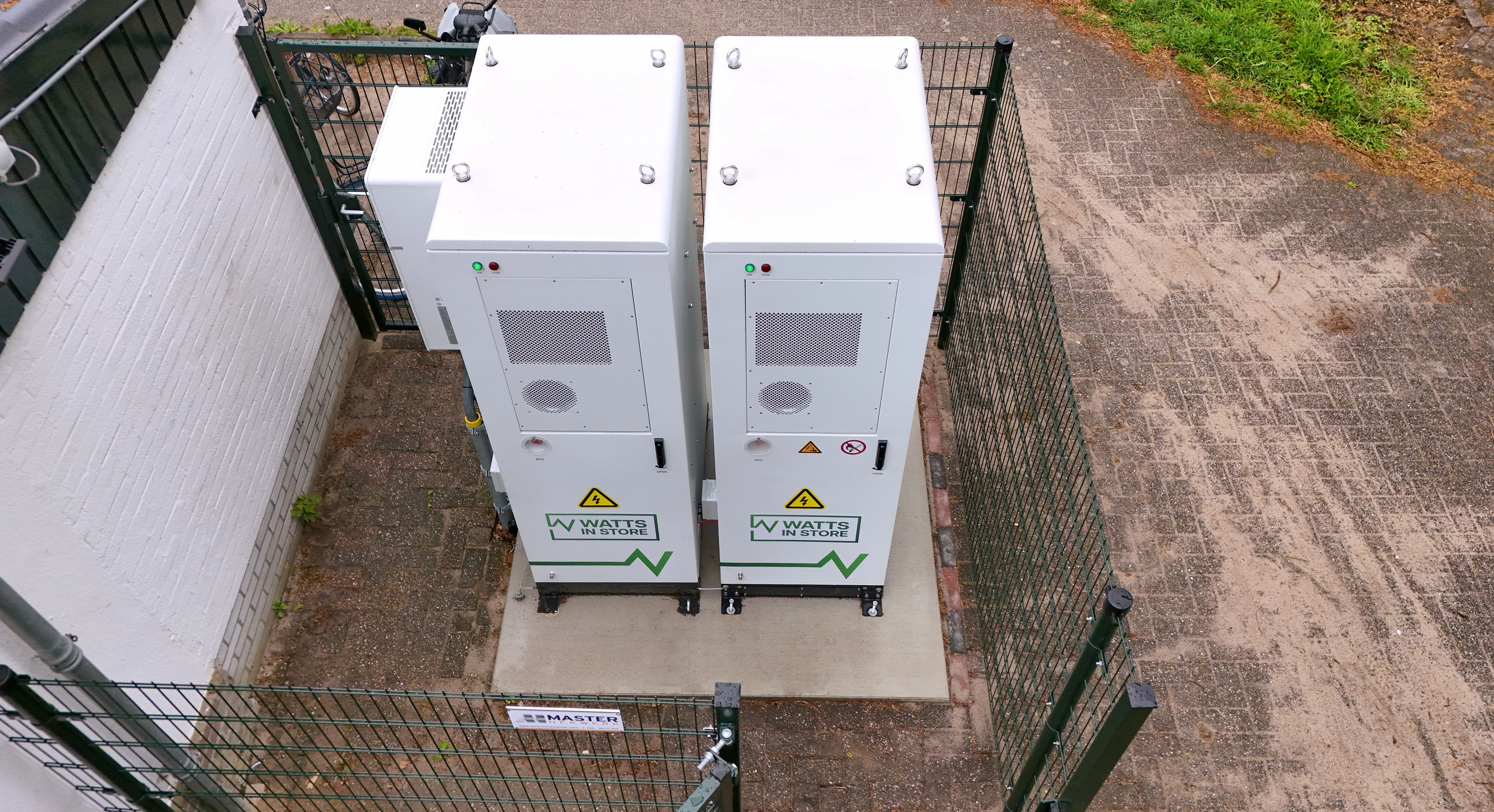Twee batterijkasten met met logo van Watts In Store. Foto gemaakt vanuit vogelperspectief.